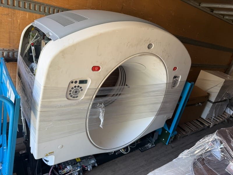 GE CT scanner gantry shrink-wrapped and loaded in an enclosed air-ride trailer for transport
