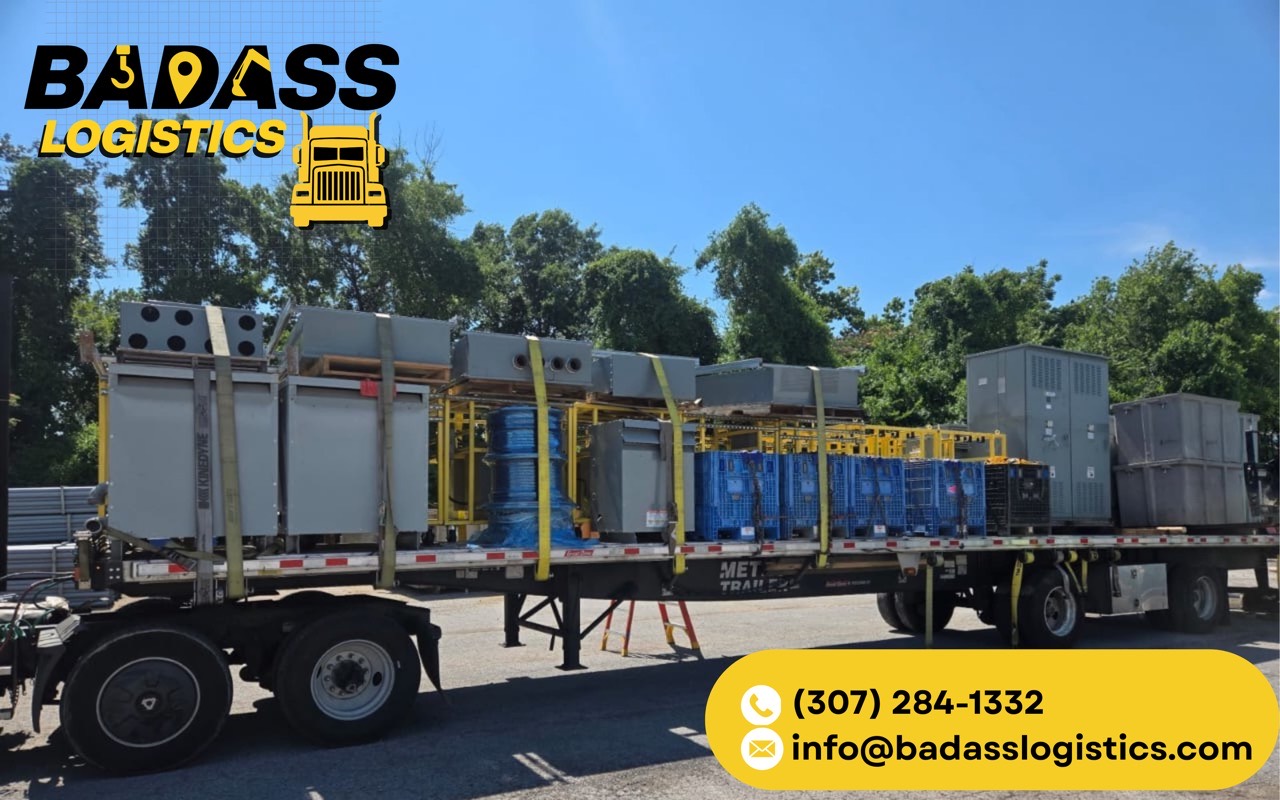 Flatbed loaded with electrical enclosures, transformers and industrial equipment, strapped down by Badass Logistics